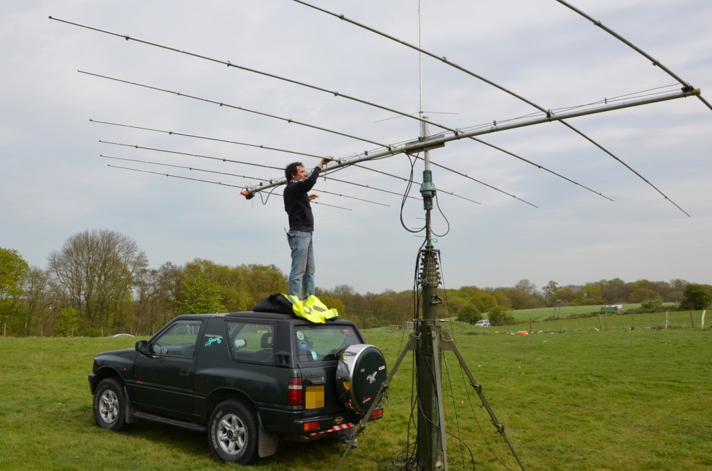 Spencer standing on the car roof adjusting the beam